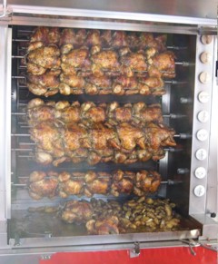 A bay of a rotisserie truck. Down at the bottom: potatoes soaking up the chicken juices